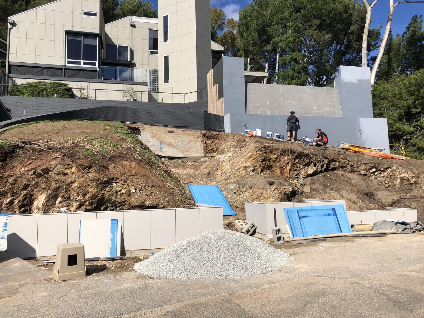 Excavated hillside with new rendered retaining walls under construction above a cut slope in Glen Osmond