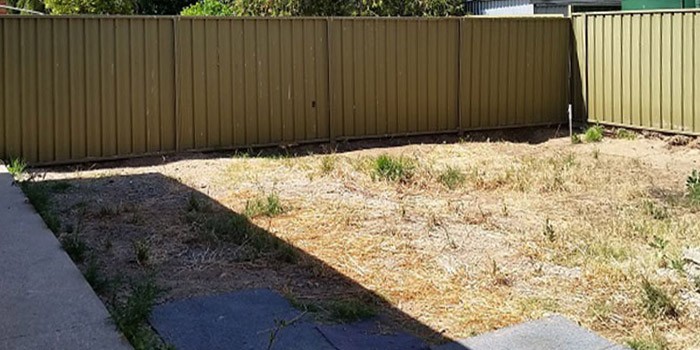 Small bare courtyard with an old steel panel fence in Glenelg, before landscaping