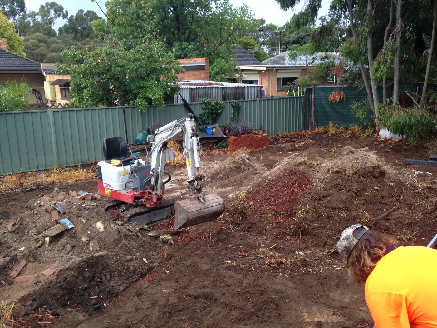 Backyard mid-excavation with a mini excavator clearing the site at a house in Oaklands Park